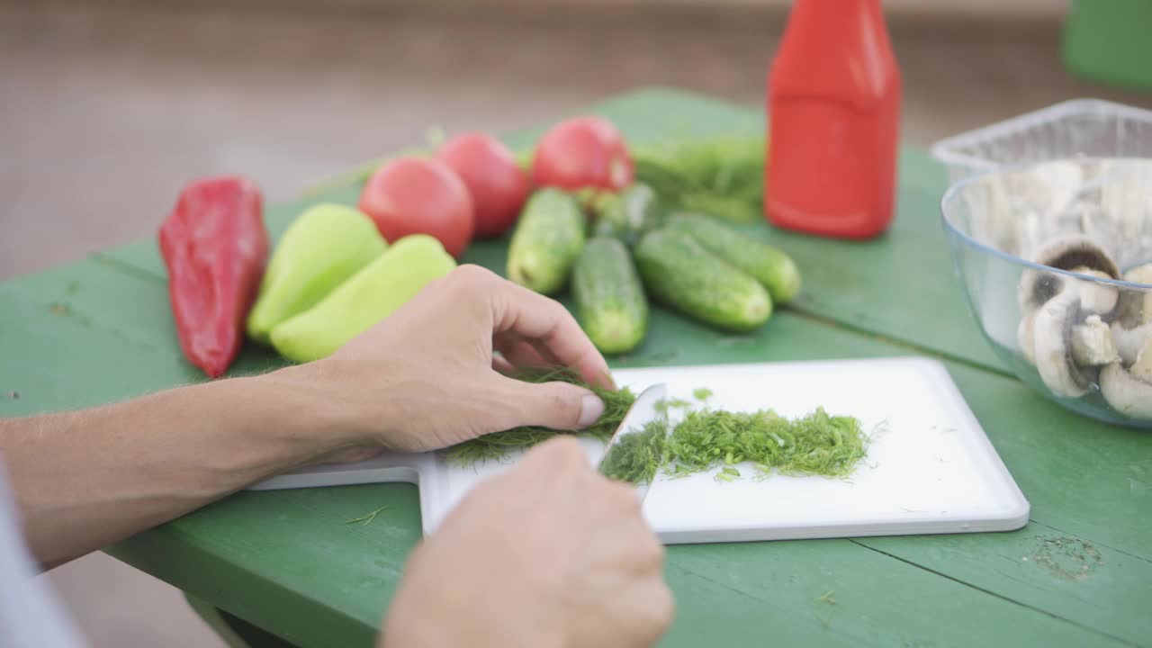 手切菜板上的香草和绿色桌子上的新鲜蔬菜的特写视频素材