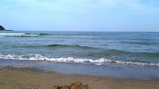 海景。风平浪静的大海，小浪翻滚到沙滩上。假期在黑海沿岸在保加利亚，城市基滕，南海滩。夏季。视频素材