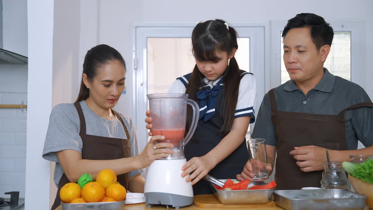 家人在厨房帮忙做冰沙，家庭关系的概念视频素材