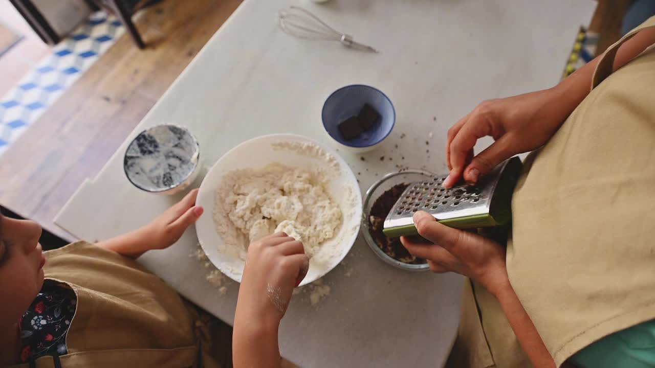 妈妈和孩子一起在厨房烘焙，混合面团和巧克力视频素材