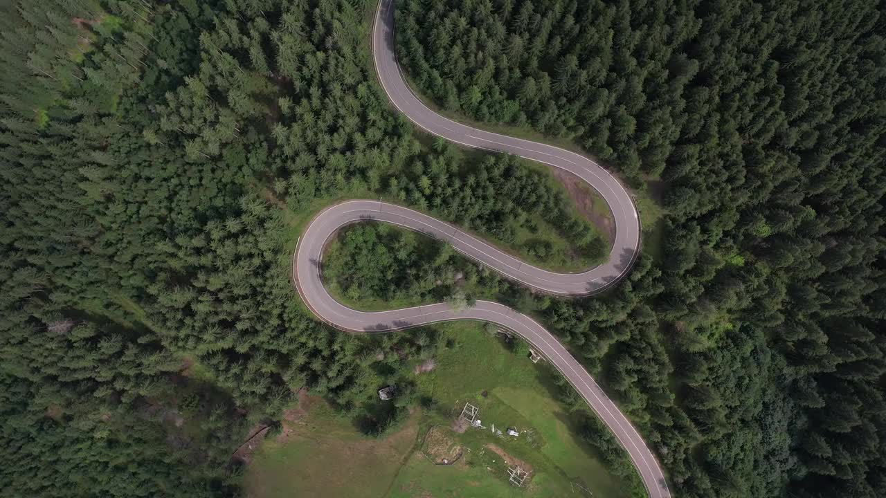 弯弯曲曲的柏油路上山林夏日。
鸟瞰图的道路穿过山和绿色的森林。视频素材