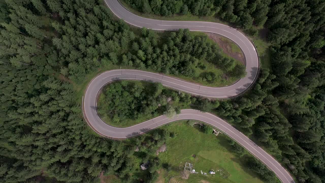 弯弯曲曲的柏油路上山林夏日。
鸟瞰图的道路穿过山和绿色的森林。视频下载