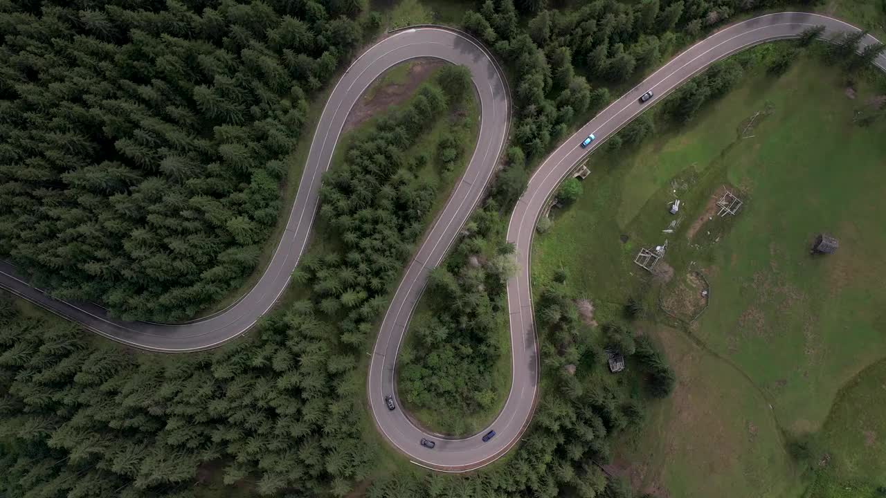 弯弯曲曲的柏油路上山林夏日。
鸟瞰图的道路穿过山和绿色的森林。视频下载