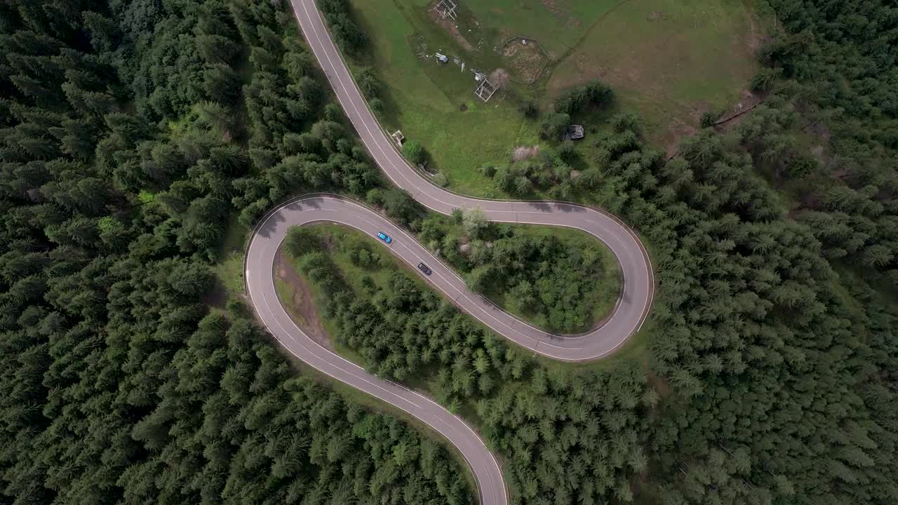 弯弯曲曲的柏油路上山林夏日。
鸟瞰图的道路穿过山和绿色的森林。视频素材