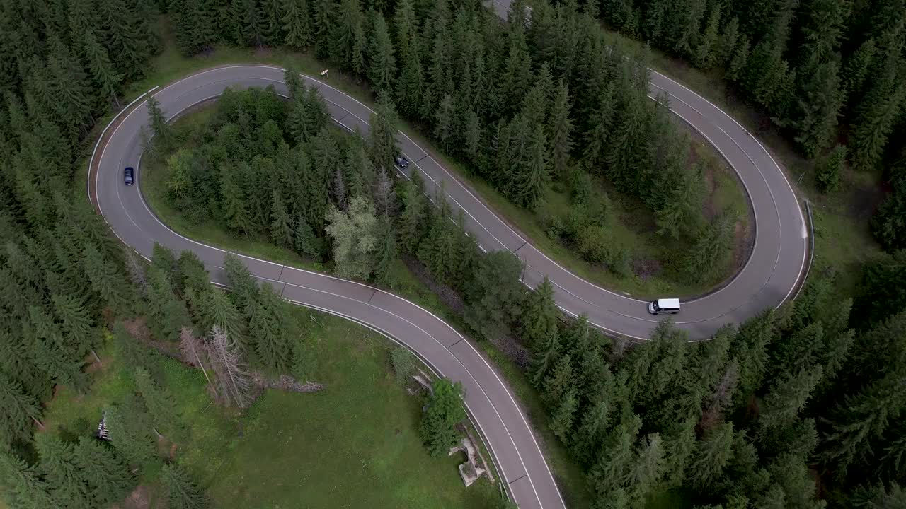 弯弯曲曲的柏油路上山林夏日。
鸟瞰图的道路穿过山和绿色的森林。视频素材