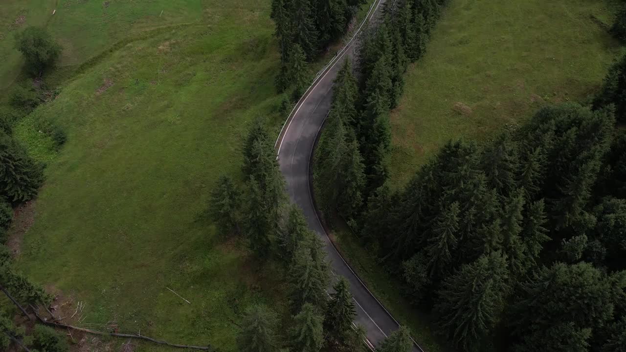 弯弯曲曲的柏油路上山林夏日。
鸟瞰图的道路穿过山和绿色的森林。视频素材