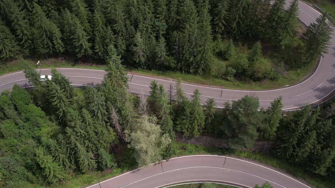 弯弯曲曲的柏油路上山林夏日。
鸟瞰图的道路穿过山和绿色的森林。视频素材