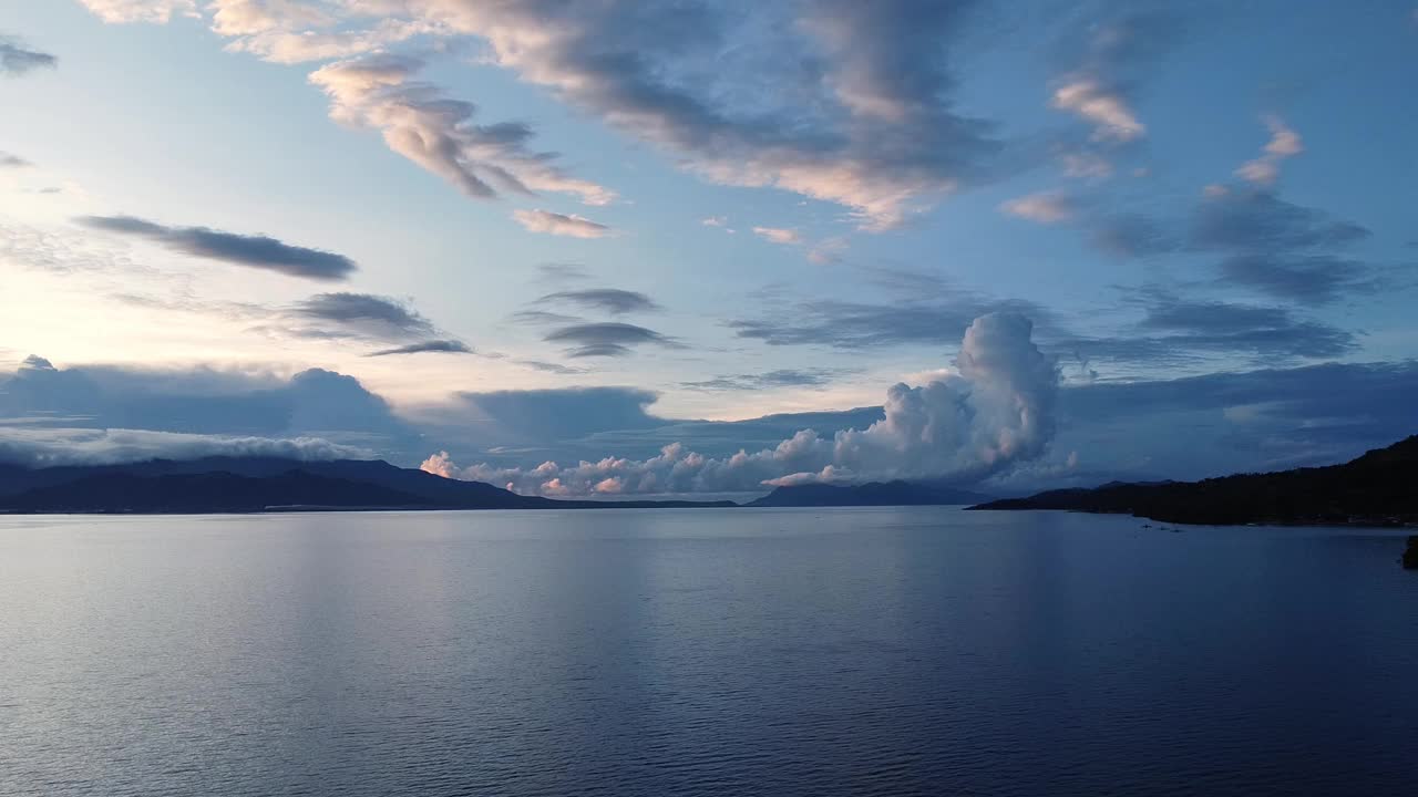 海面上的黎明映衬着热带山脉和云层视频素材