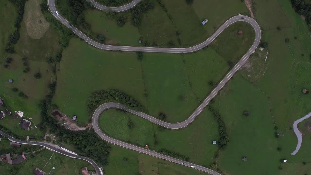 弯弯曲曲的柏油路上山林夏日。
鸟瞰图的道路穿过山和绿色的森林。视频素材