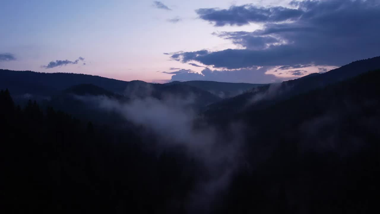 日落时雾气缭绕的山间松林。雾蒙蒙的风景与冷杉林。视频下载