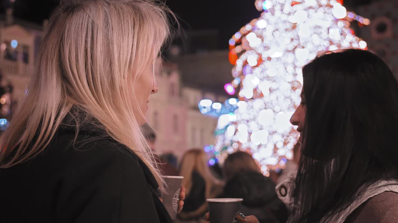 两个微笑的女孩在镇广场庆祝圣诞节视频下载