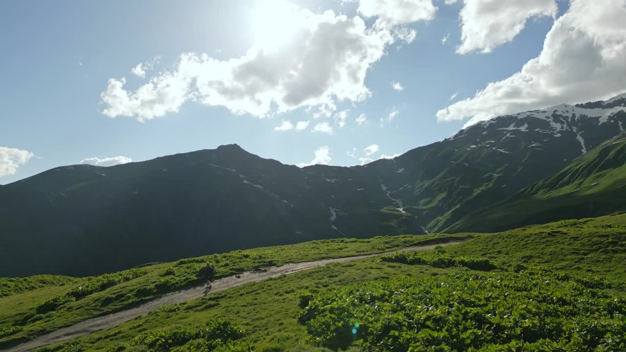 一个孤独的人在斯瓦涅季山脉的高山草地上旅行。山区景观鸟瞰图。探索自然，孤独，冒险，徒步旅行，抑郁。迷人的风景环境。无人机拍摄的视频素材