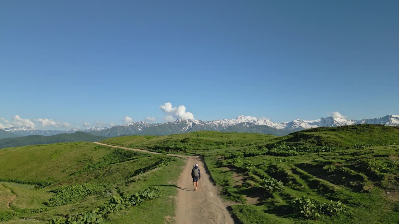 斯瓦涅季山脉高山草地上孤独旅行者的航拍。在遥远的大自然中徒步旅行。突出孤独，心理健康，冒险，荒野。适合旅行、徒步旅行。无人机拍摄的视频素材