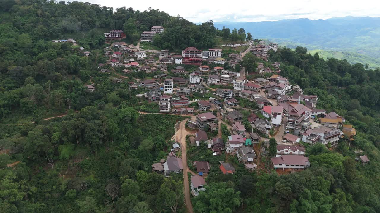 航拍照片展示了一个被茂密的森林和风景环绕的山村，突出了自然和人类居住的融合。视频下载