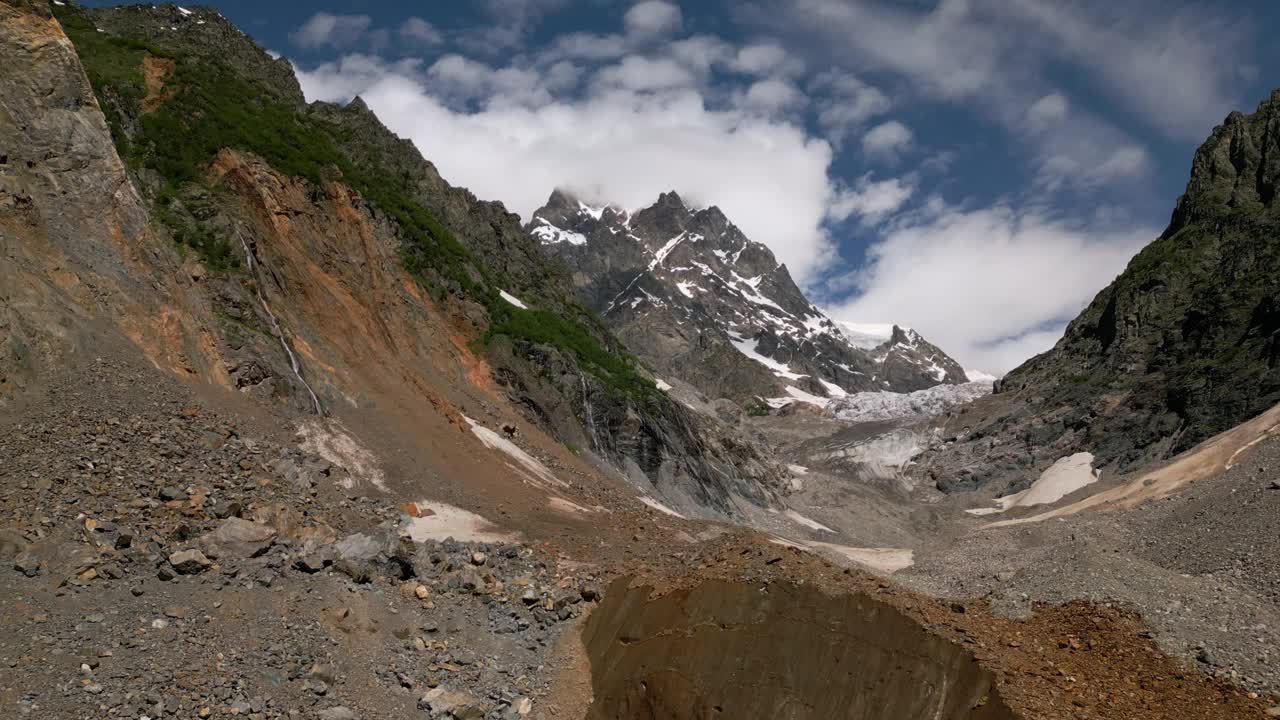 格鲁吉亚斯瓦涅季山脉Chalaadi冰川航拍图。岩石景观，白雪覆盖的山峰，崎岖的地形。风景优美的山脉上的云。徒步旅行的目的地，原始的自然，荒野。无人机视频素材