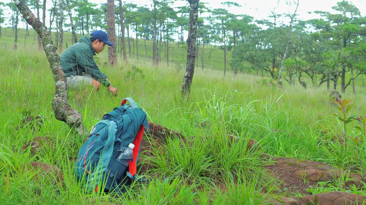 徒步背包躺在森林的地面上，冒险家在泰国富索岛国家公园徒步旅行中休息，欣赏令人叹为观止的山景。视频下载