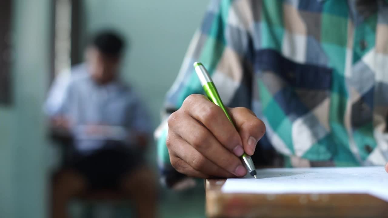 学生们在教室里紧张地做考试。高中学生评估考试视频素材