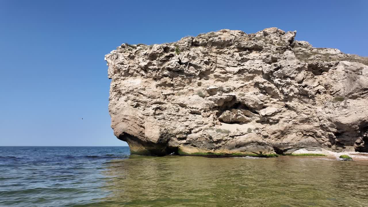 在克里米亚，一个岩石悬崖面对着平静的黑海水域。视频素材