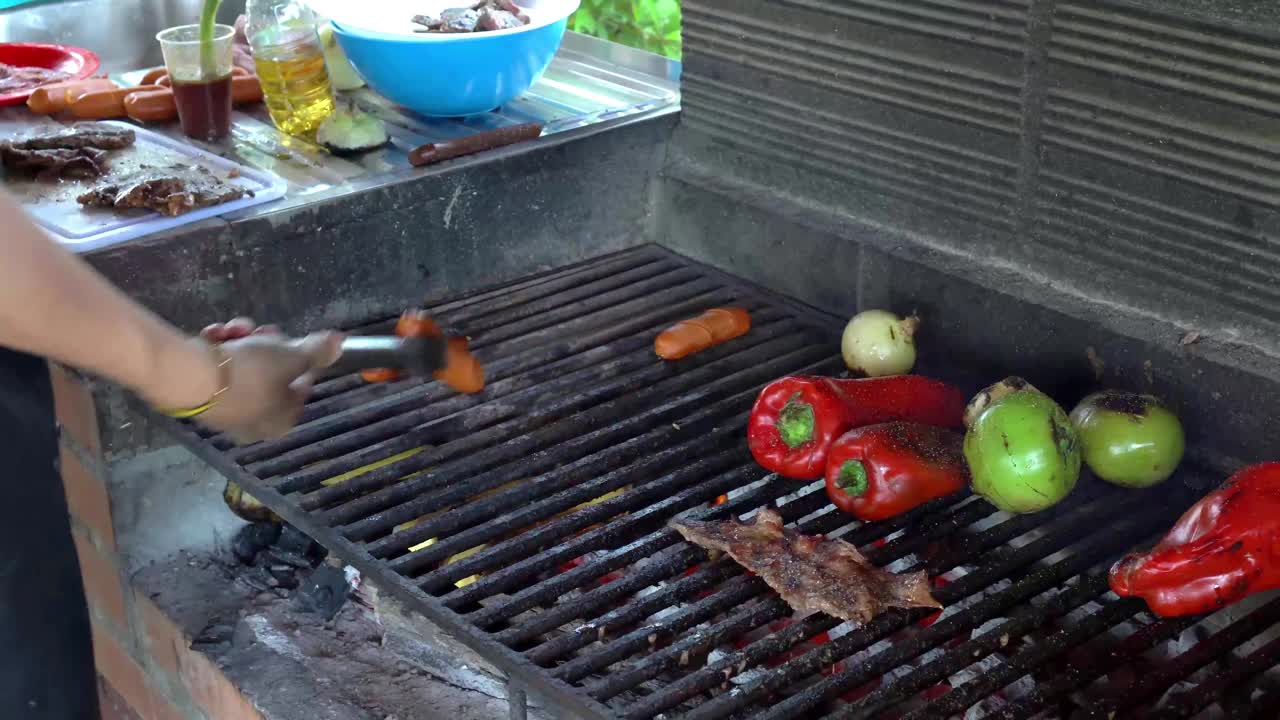 在烤肉台上烤红椒、青椒、香肠和肉。视频素材