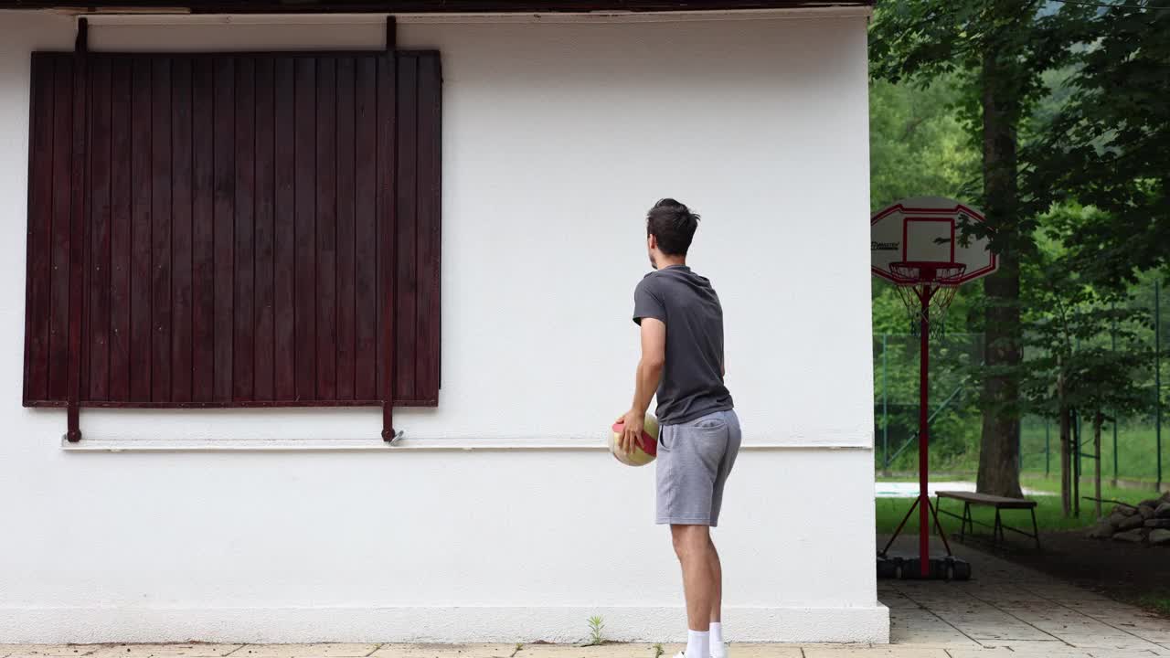 排球运动员把球靠在墙上练习排球技术。传球，击球，挖掘。运动自动化。特殊的训练视频素材