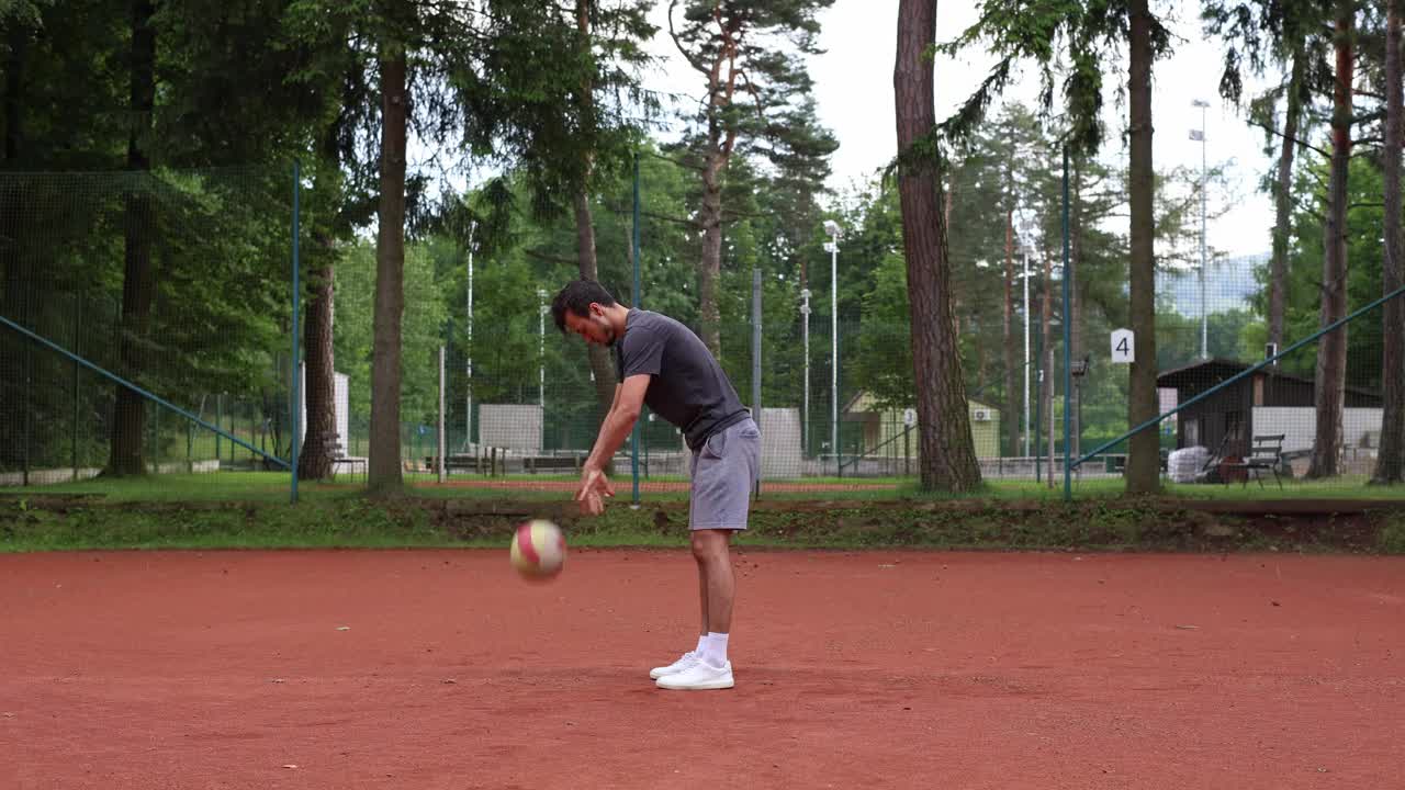 成年运动员在室外红土场上练习排球技巧。传球，击球，挖掘。运动自动化视频下载