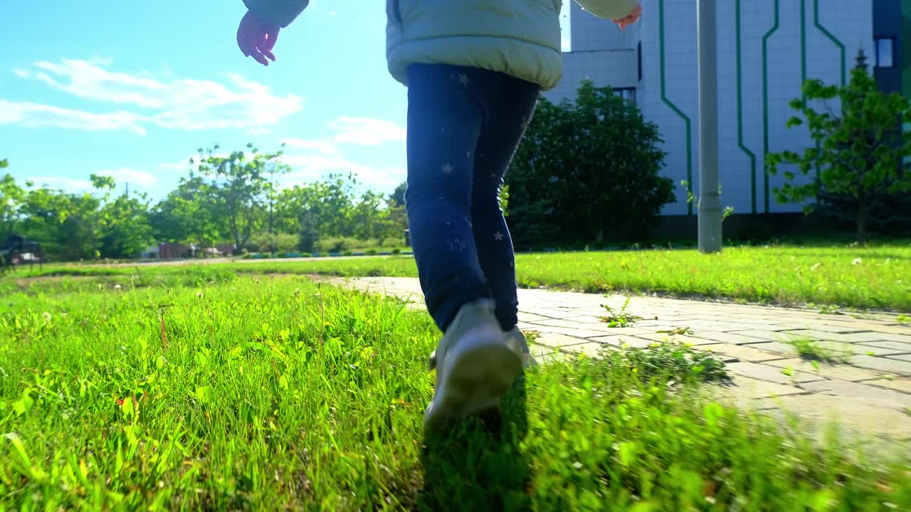 一个漂亮的孩子在公园外面玩耍和微笑。快乐的小女孩在春天的一天在外面玩耍。可爱的白人小孩在花园里散步，笑着。视频素材