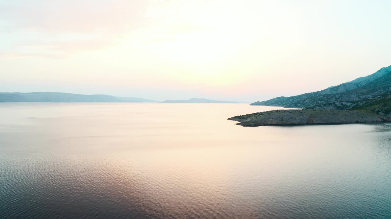 海岸线与山的剪影与柔和的天空色调视频素材