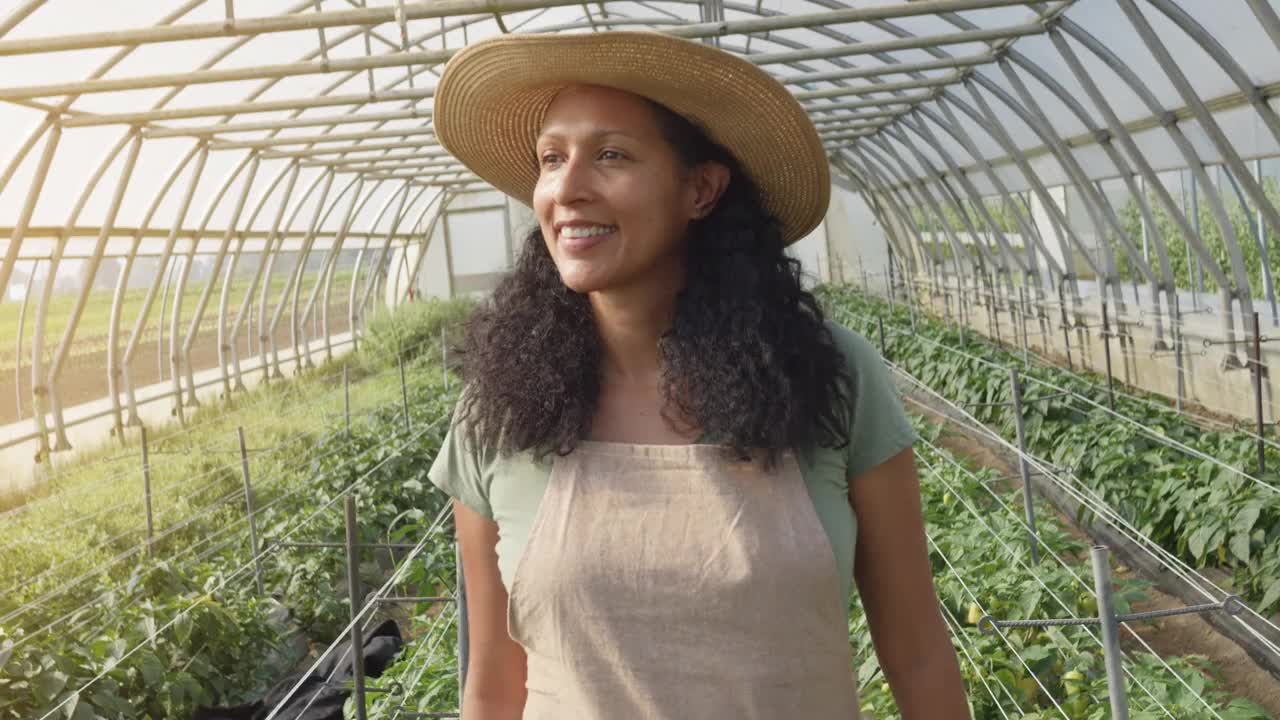 微笑的西班牙妇女走在温室前视图跟踪拍摄视频素材