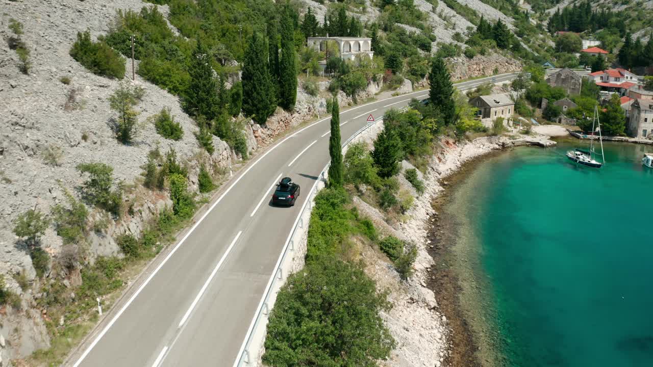 带顶棚箱的汽车沿着沿海道路行驶，经过泻湖视频素材