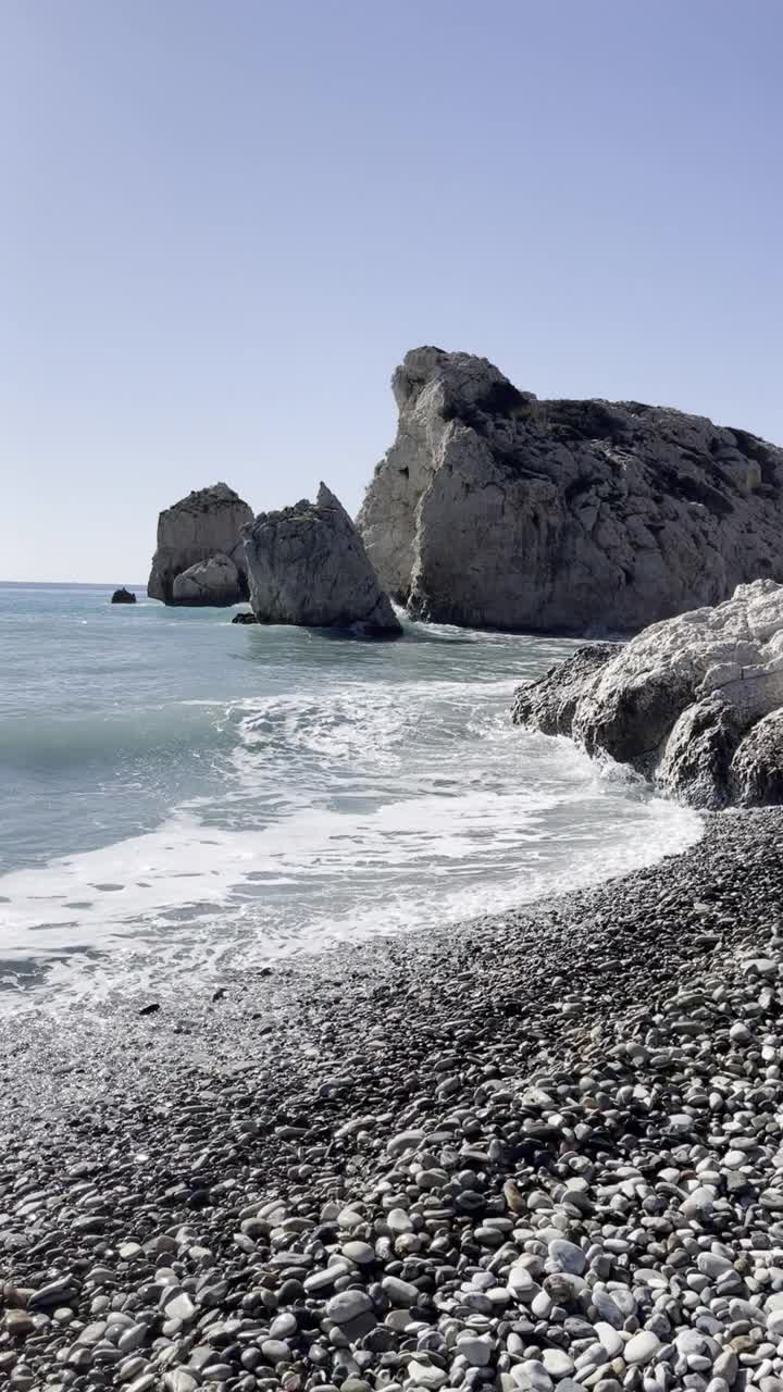 一个美丽的岩石海滩，被海浪和清澈的蓝色海水包围视频下载