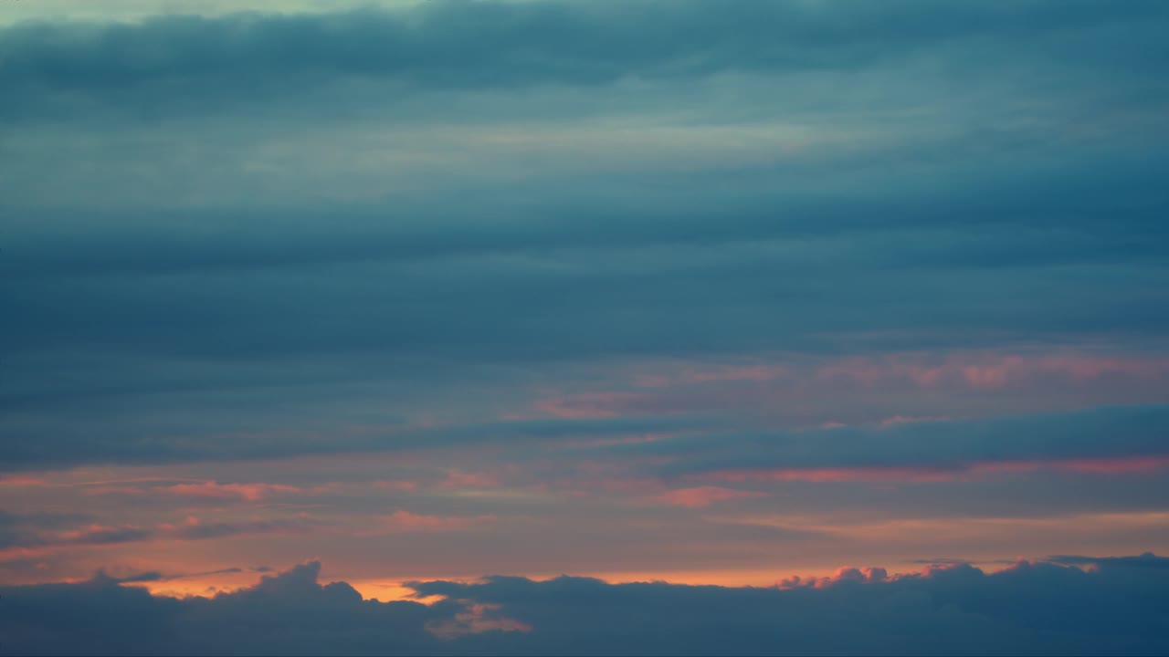 天空布满了一层层的云，以浅蓝色为主，略带粉色，营造出一种宁静的氛围。视频素材