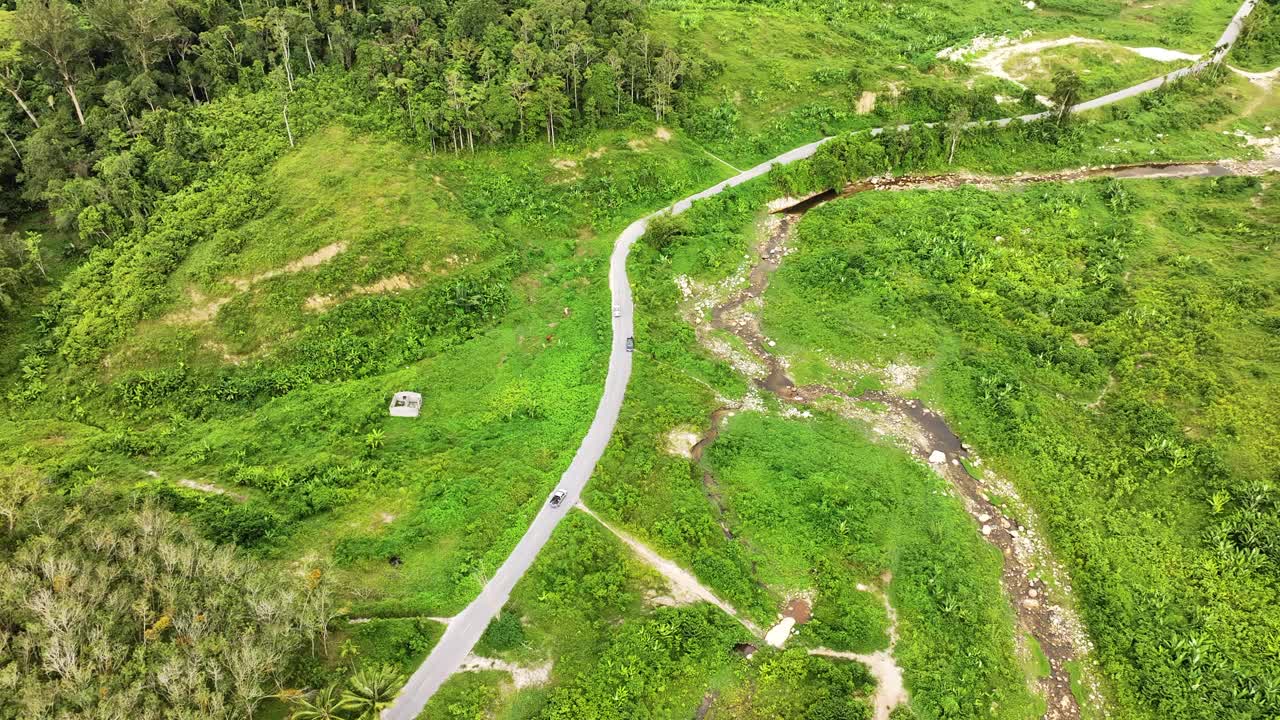 空中无人机看到美丽的天空道路在山顶与绿色丛林。在山路弯道上的公路旅行。视频素材