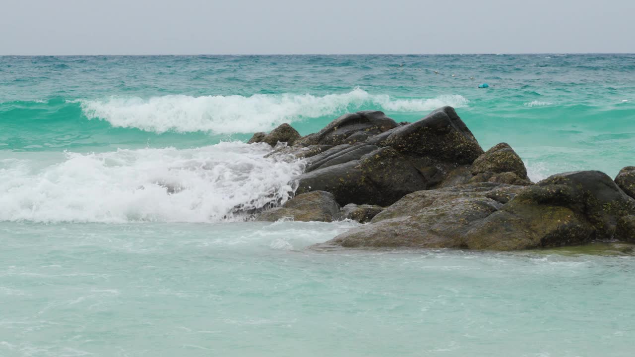 碧绿的海浪冲击着岩石海岸视频素材