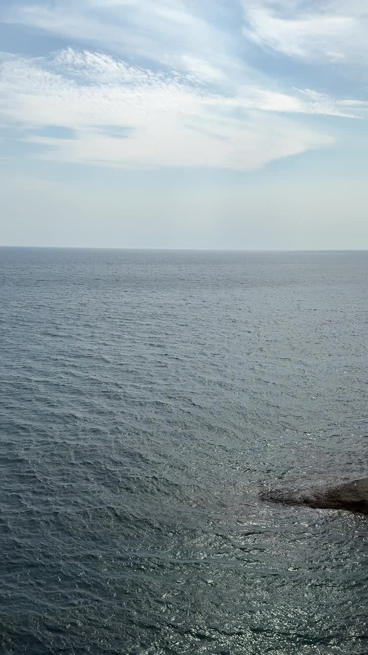 海洋碧蓝粼粼，水面和天空中的白云，垂直视频视频素材