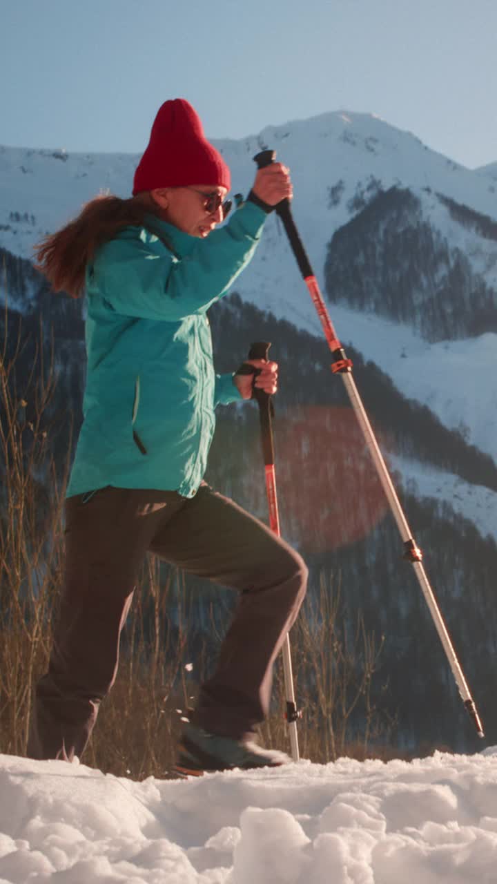 一名女子在雪山徒步旅行，用北欧徒步棒来保持健康。一位年长的女性徒步旅行者在散步视频下载