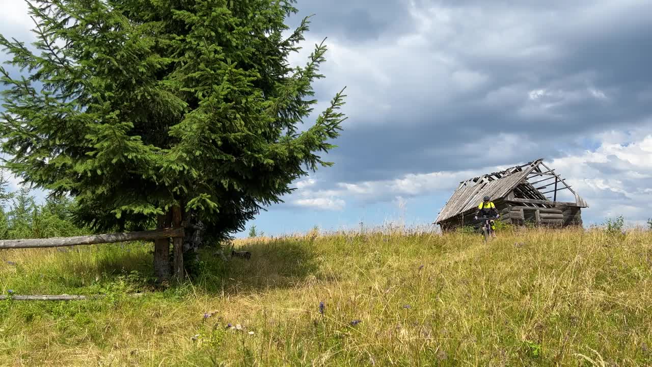 骑电动山地车的人沿着山上长满草的小路在户外骑行。视频素材