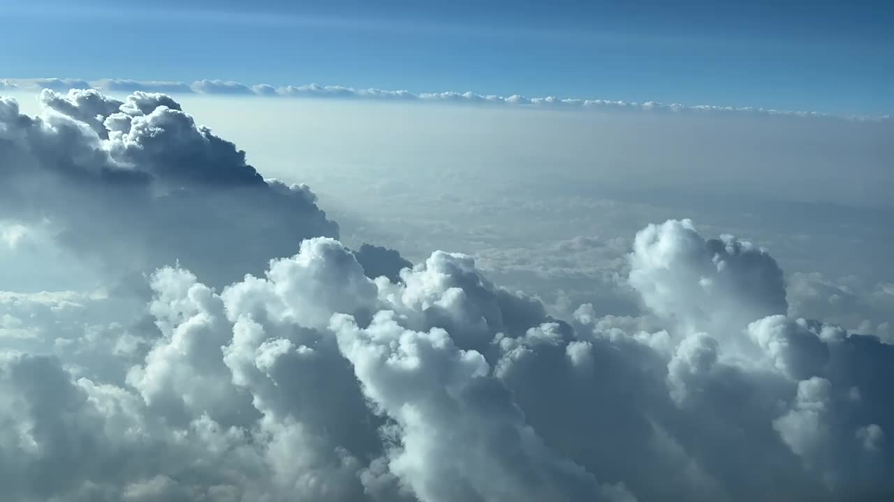 独特的身临其境的飞行员POV在一个实时飞行，通过一个蓝色的天空飞过一些暴风雨云做右转，以避免恶劣天气。4 k 60 fps视频素材