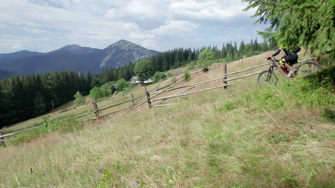 骑电动山地车的人沿着山上长满草的小路在户外骑行。视频素材