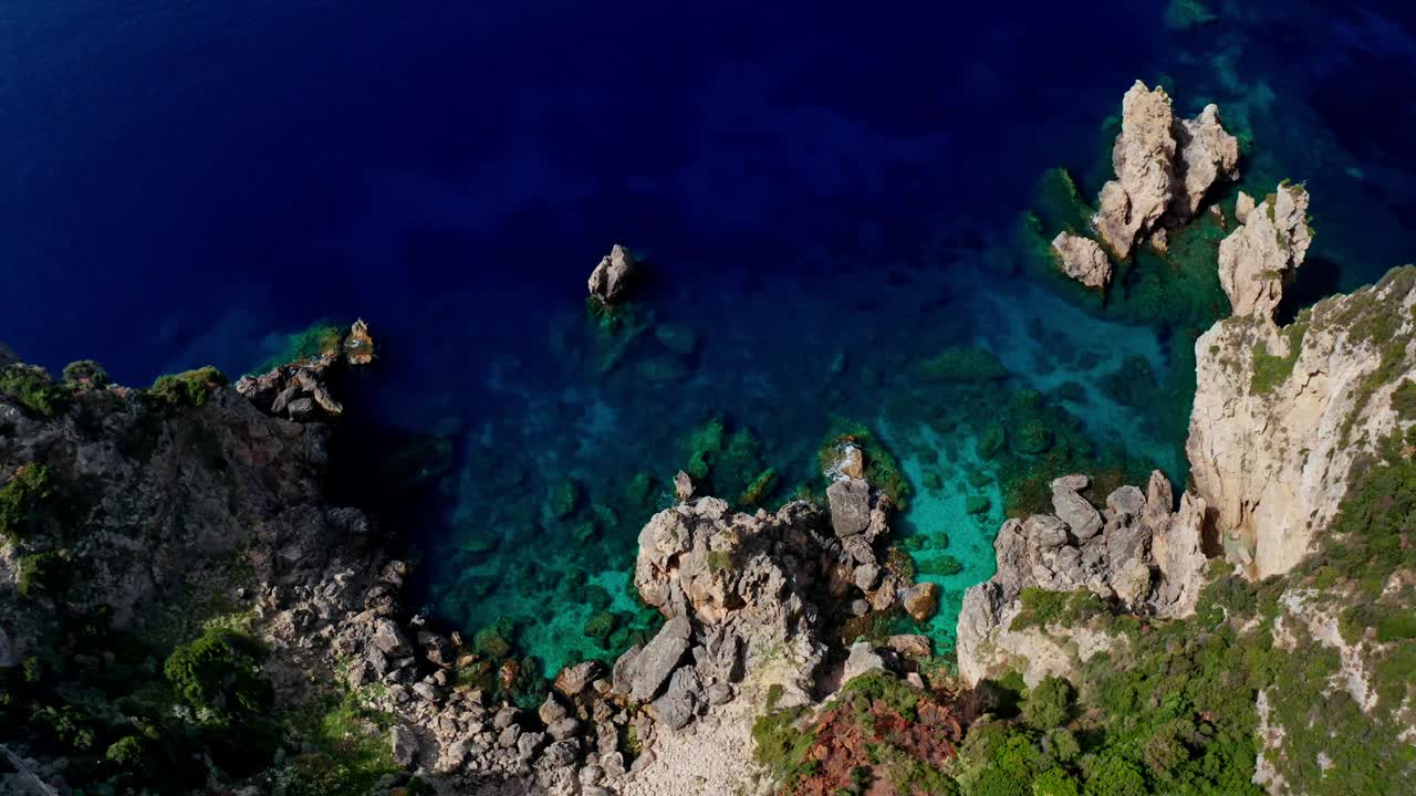 由上而下的无人机拍摄的希腊科孚岛古奥卡斯特里萨风景如画的岩石海岸线。
生机勃勃的绿松石海。摄影机升起，展现出壮丽的景色。视频素材