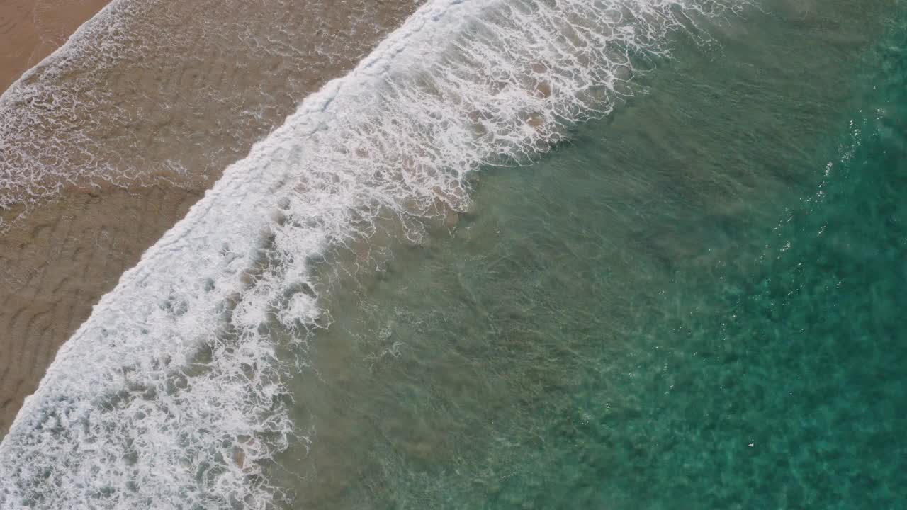 美丽的绿松石水波沿着田园诗般的清澈，浅，沙滩海岸线破碎。视频素材