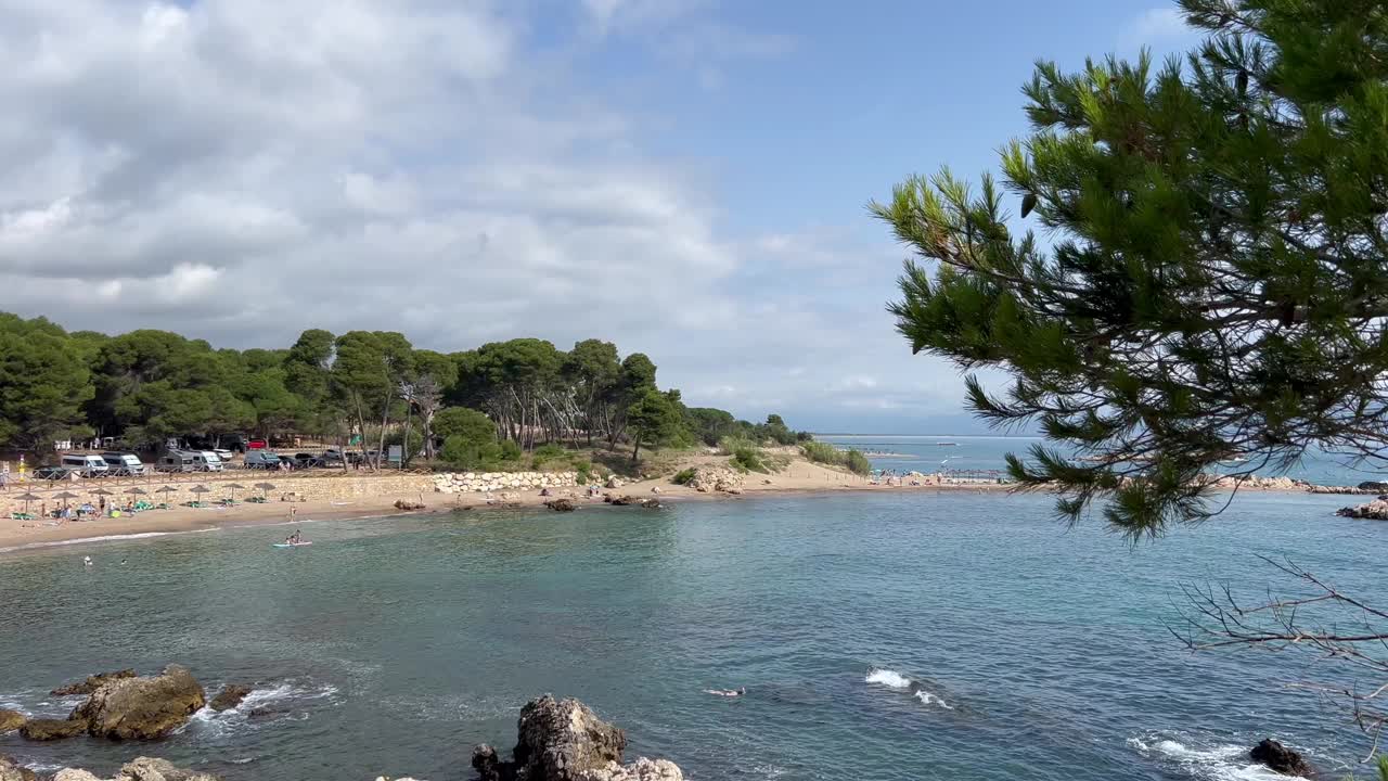 夏天的场景在海岸布拉瓦海滩，西班牙，具有清澈的水，沙滩海岸，和郁郁葱葱的绿色背景。视频下载