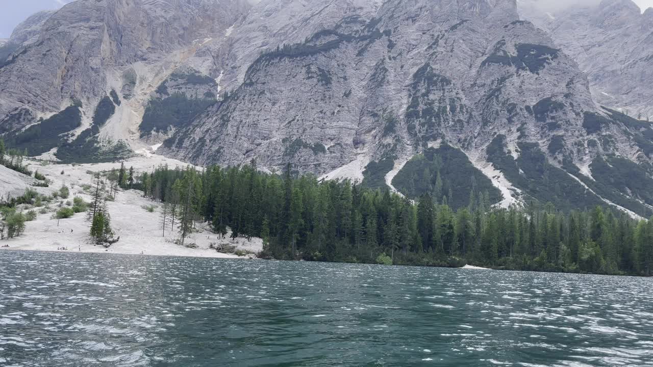 一个宁静的山湖，周围是郁郁葱葱的森林和雄伟的山峰视频下载