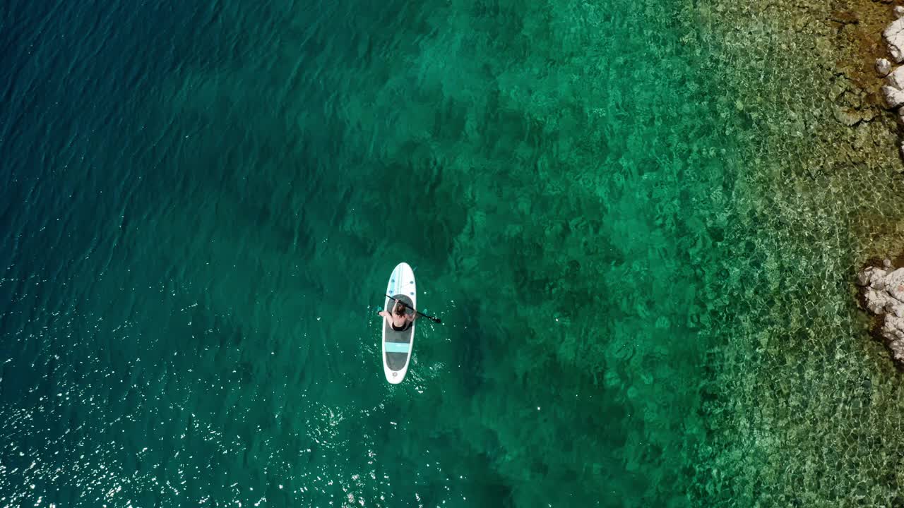 游客的桨坐在船上航行在蔚蓝的大海视频素材