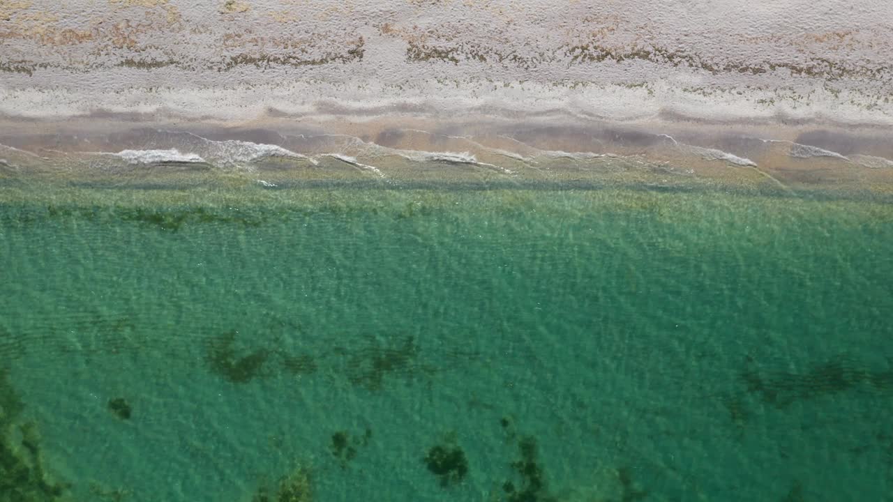 一个原始的海滩碧绿的海水和温柔的波浪，鸟瞰图视频素材