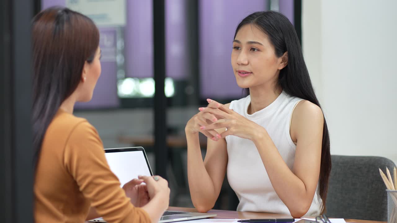 商务会议——两个亚洲女人在办公室聊天。视频素材