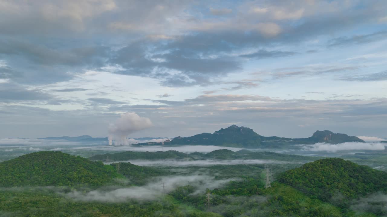 4K超缩视频:早晨鸟瞰图，雾在高山流动，雾或云移动，蒸汽从燃煤电厂的高管道排放的背景视频下载