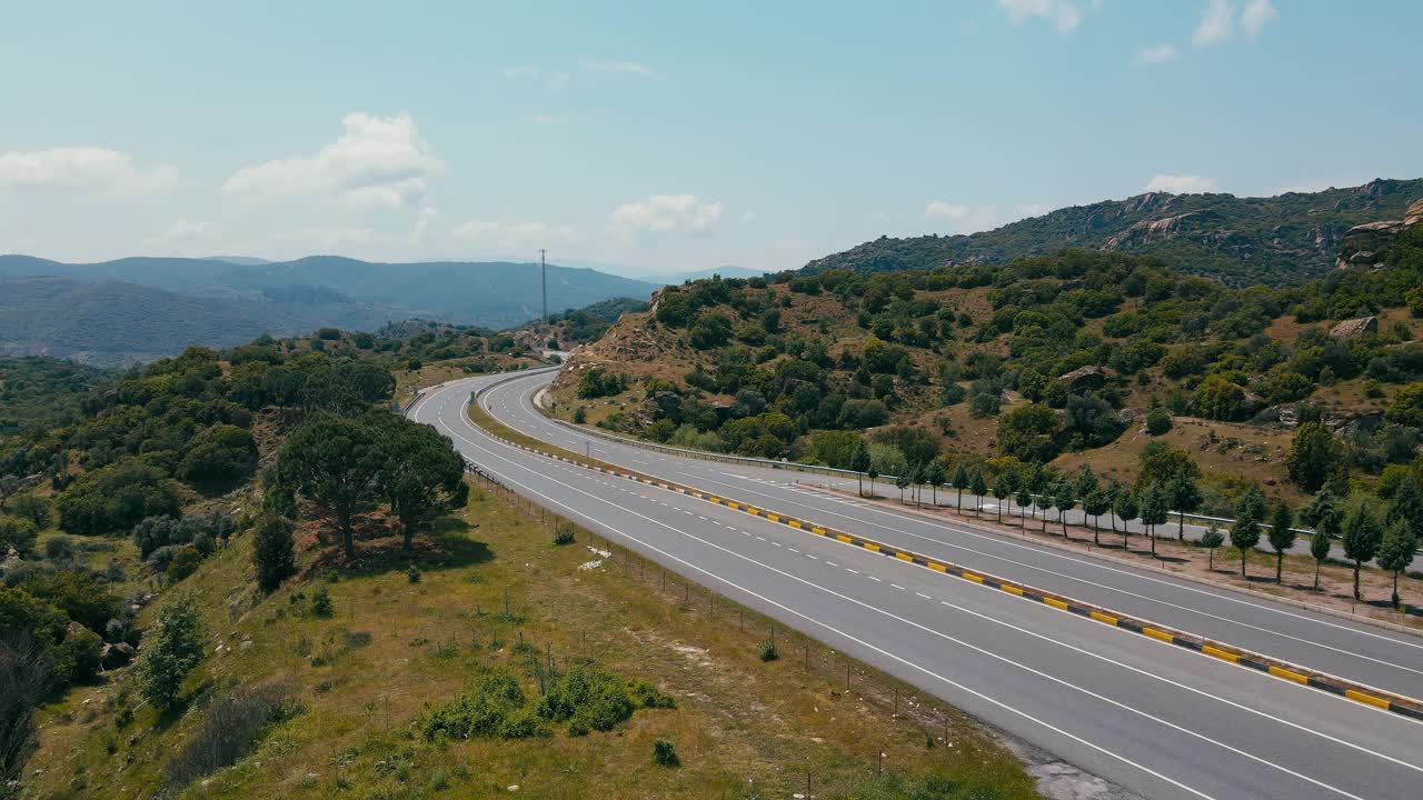 电动汽车行驶在高速公路上，穿过绿色的丘陵山谷视频素材