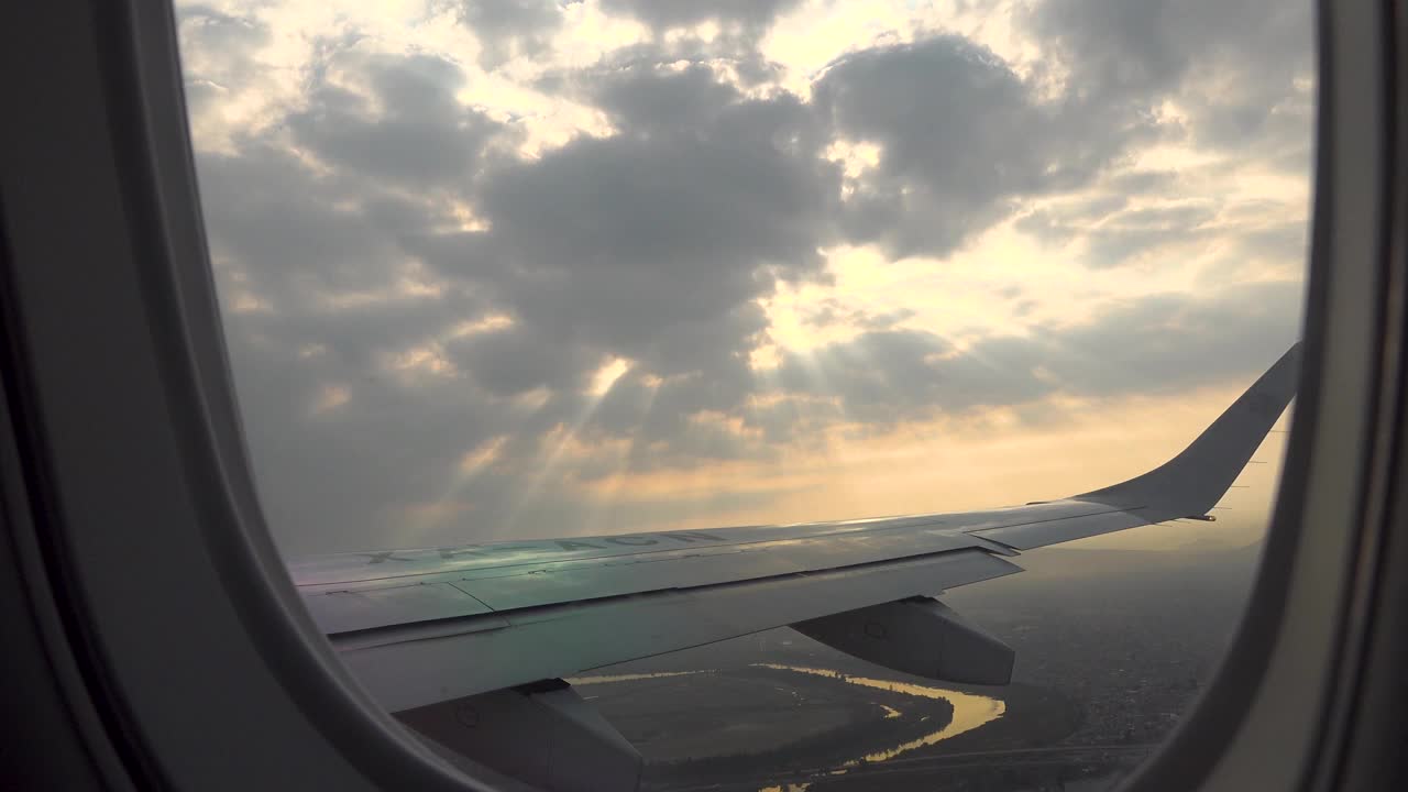 从日出时在湿地上空飞行的飞机的窗户往外看视频素材