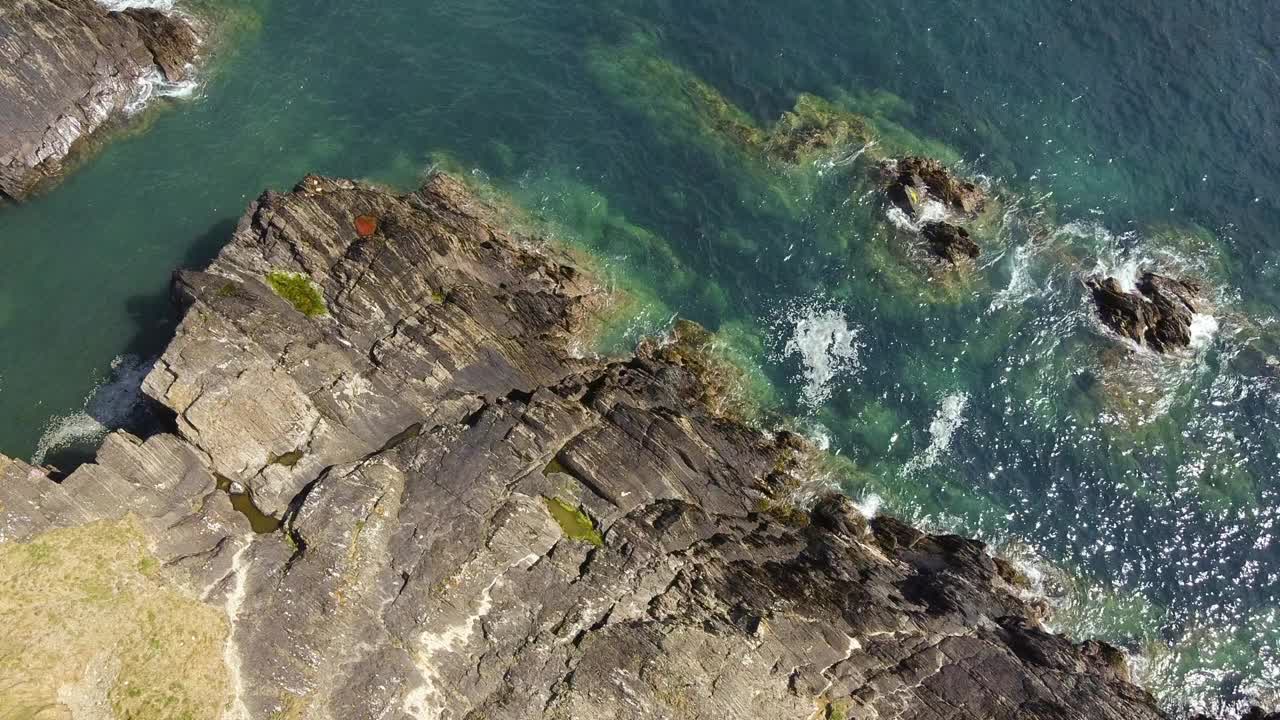 以水体为背景的岩石海岸线。水似乎平静而清澈，远处可以看到一些岩石。视频素材