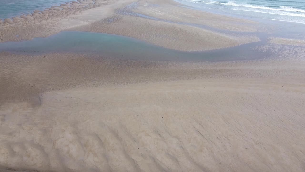 沙滩上覆盖着沙子，海水很平静。一个人影也没有。视频素材